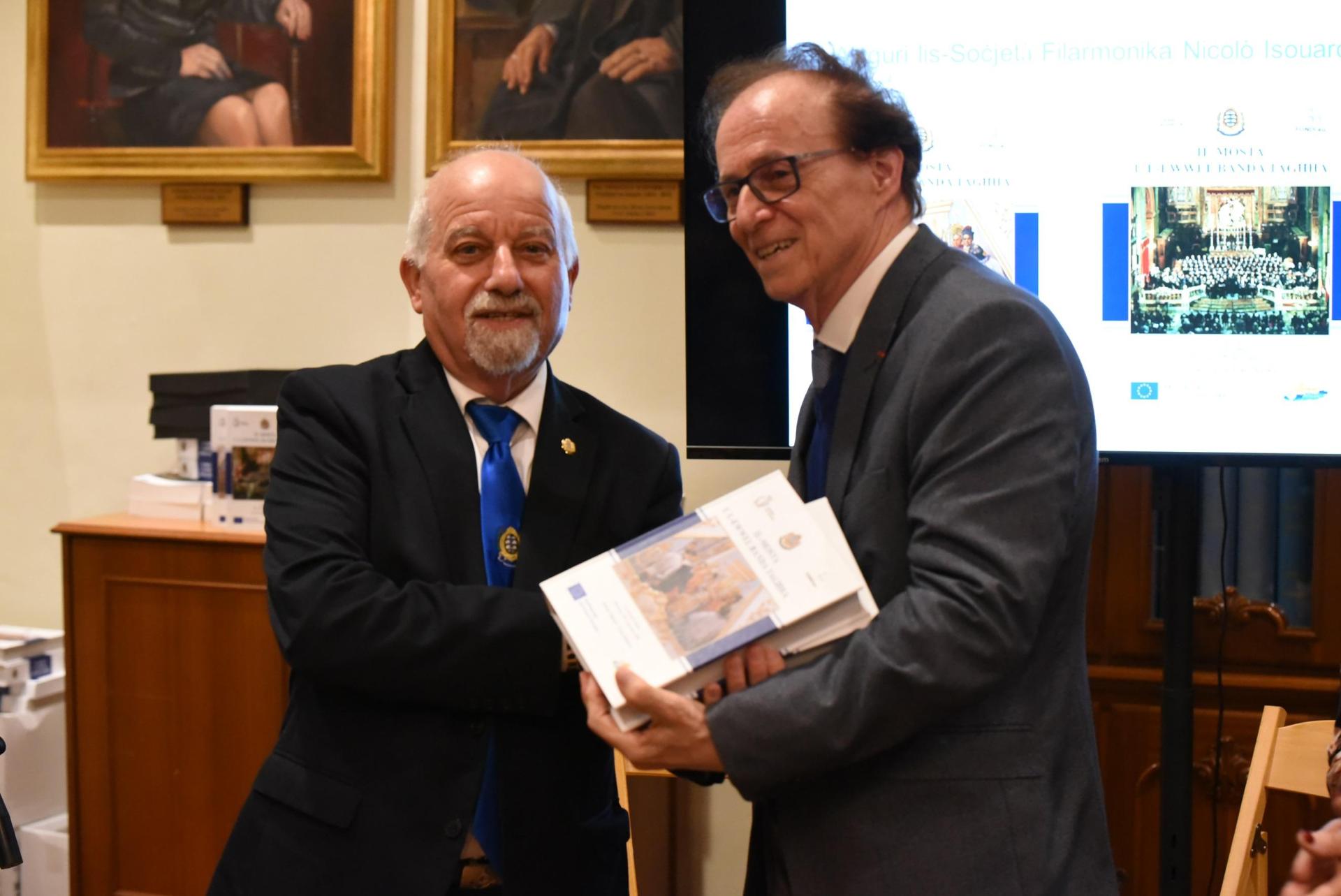 The editor Frans Deguara presents another copy to Dr Charles Xuereb, the principal guest of the event.