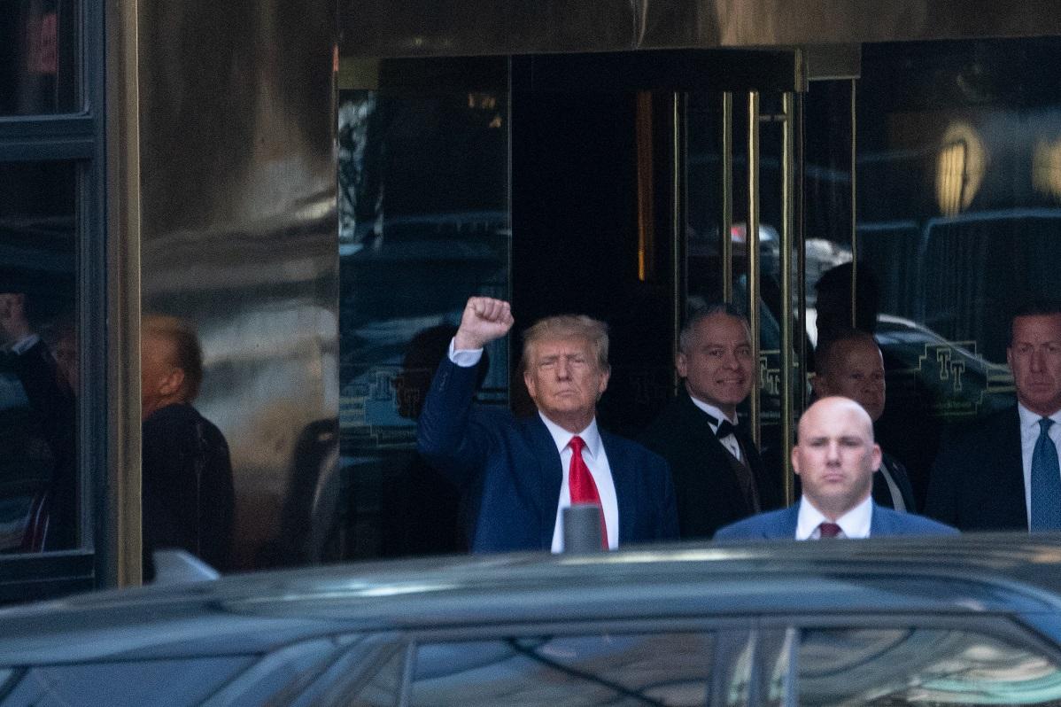 Trump raises a fist towards the crowd as he leaves Trump Tower to head to court. Photo: AFP