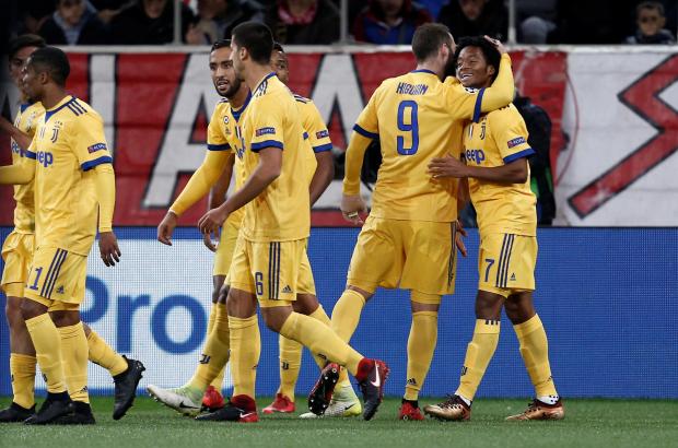 Juan Cuadrado is mobbed by his Juventus team-mates after scoring at Olympiakos.