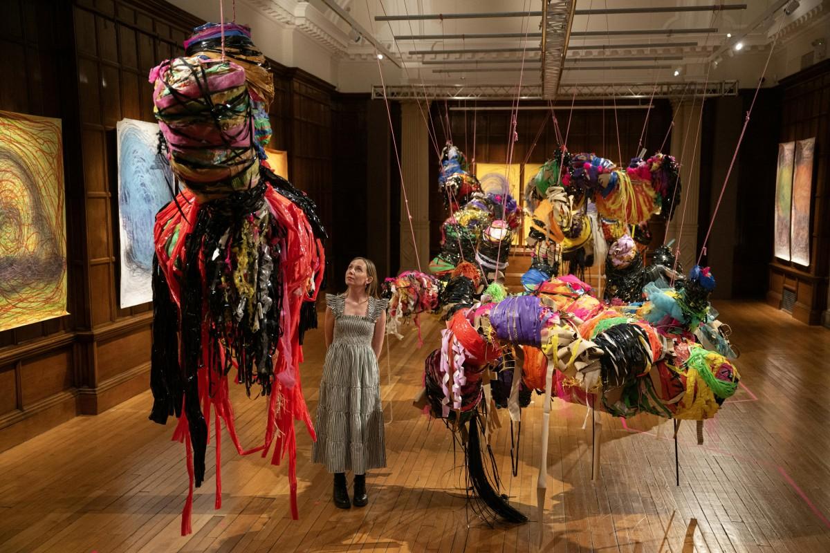 A person poses with an art installation entitled <em>Conversations</em> by Nnena Kalu. Photo: Oli Scarff/AFP