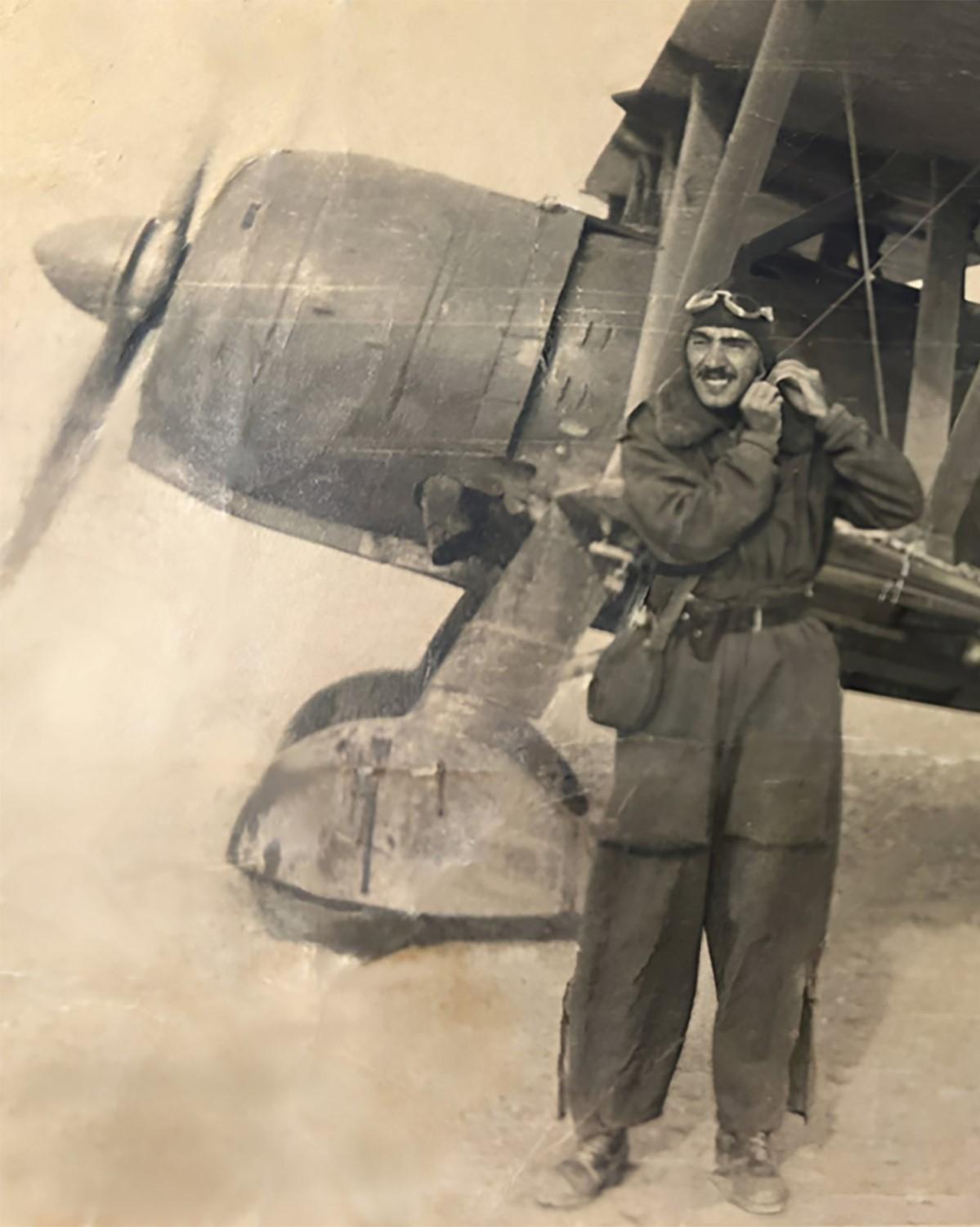 A young Faliero Gelli dressed in his uniform near his plane.