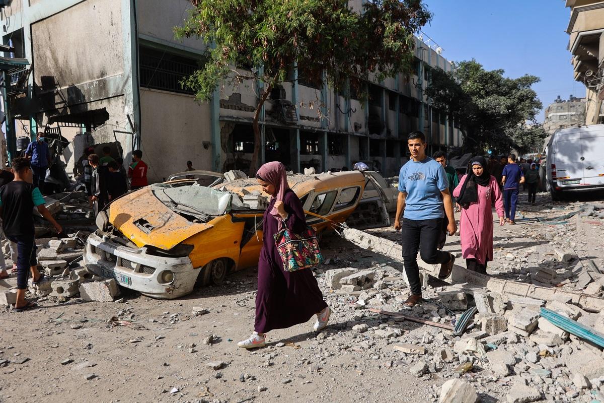 People walk over debris in front of the Fahmi Al-Jarjawi School in Gaza City. AFP.
