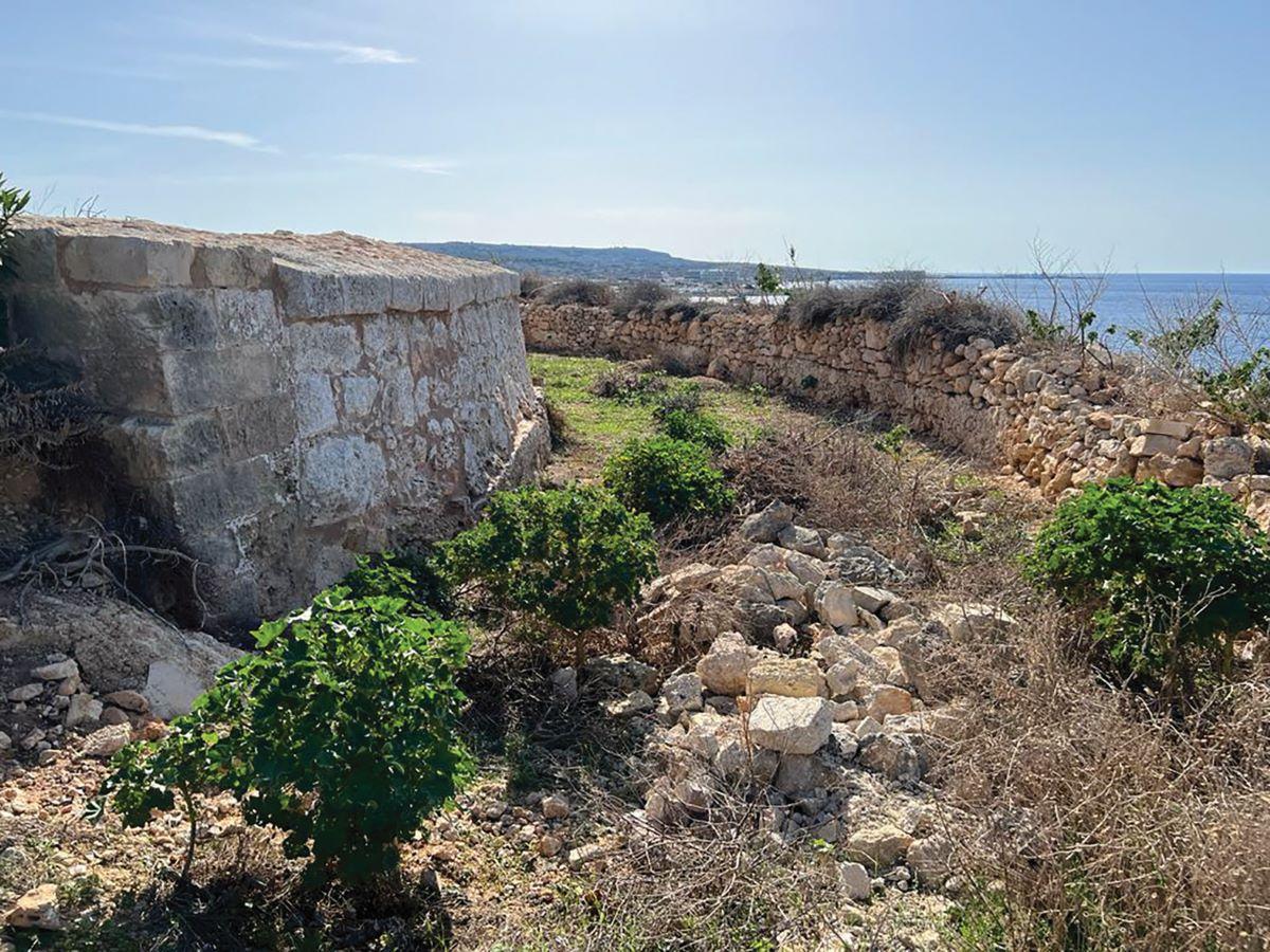 The rock-hewn ditch around the gun platform. Note the two types of masonry used where the gun platform ends, i.e.: neatly cut masonry blocks resting alongside the plastered pietra a secco revetment of the scarp wall. Photo: Author&rsquo;s collection