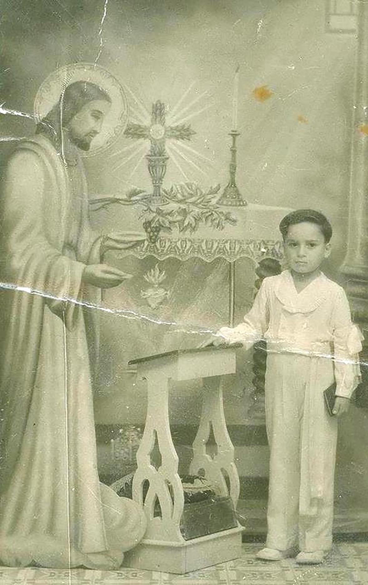 A cropped photo-card (that is, a photograph on the back of a postcard) to commemorate Joseph Caruana celebrating his First Holy Communion, about 1943.