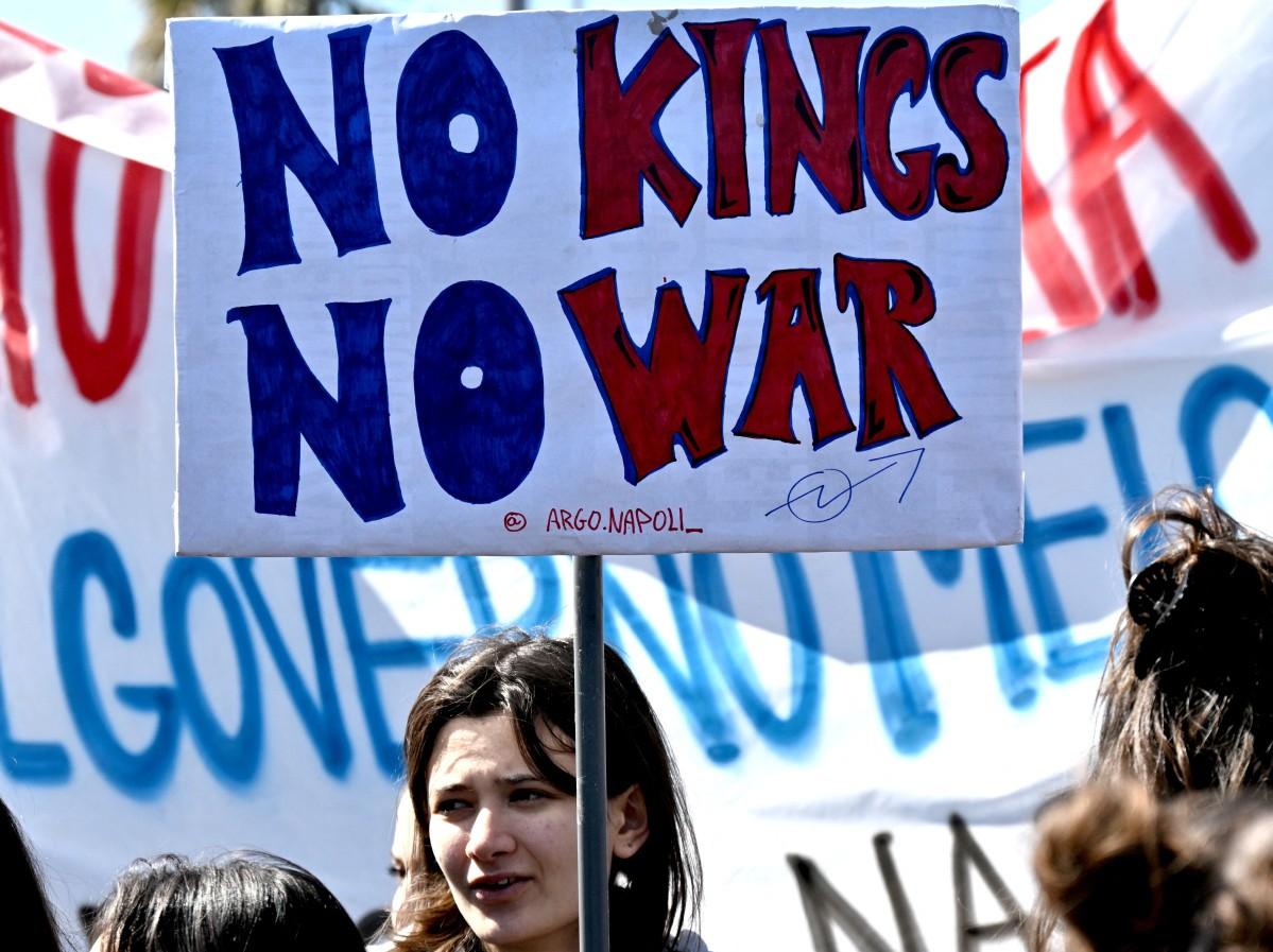 A participant carries a banner as she walks with others during a demonstration against the Middle East war entitled &ldquo;No Kings&rdquo;, in Rome on March 28, 2026. Photo: AFP