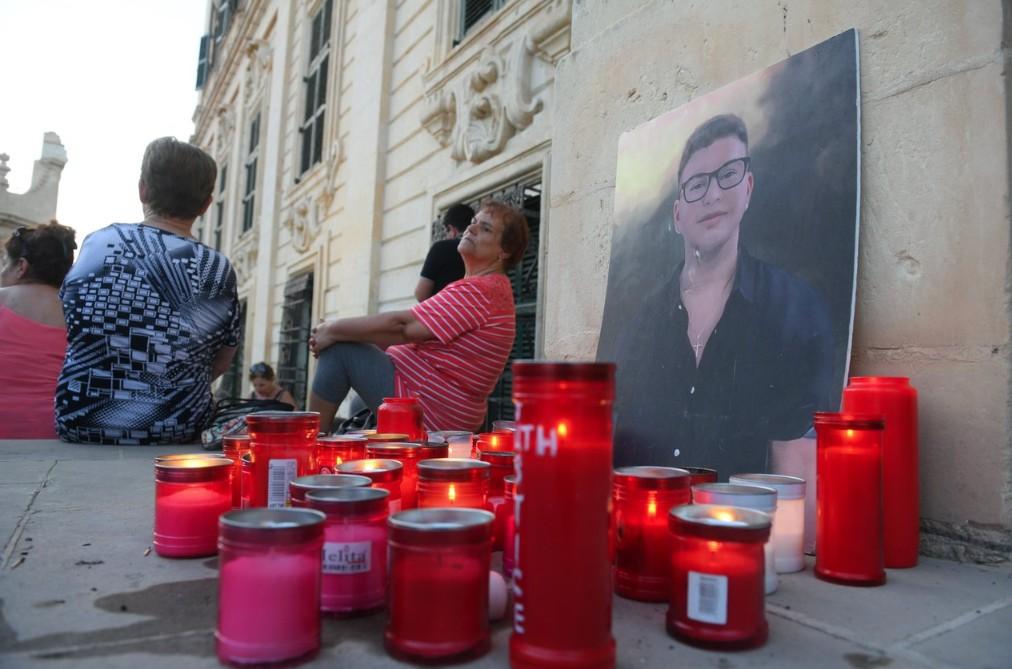 Candles are lit in front of a portrait of Jean Paul Sofia, who died in a construction site collapse in 2023. Photo: Matthew Mirabelli