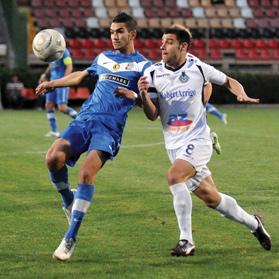 Mosta defender Ferdinando Apap (left) shapes up to clear the ball as Sliema Wanderers midfielder Mark Scerri closes in.