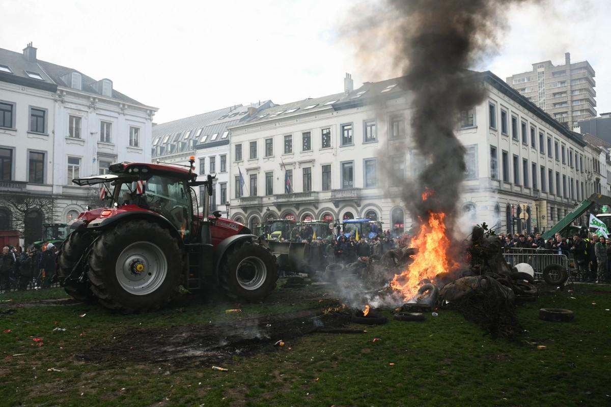 Farmers stand next to tractors and a fire near the European Parliament at the Place du Luxembourg. Photo: AFP