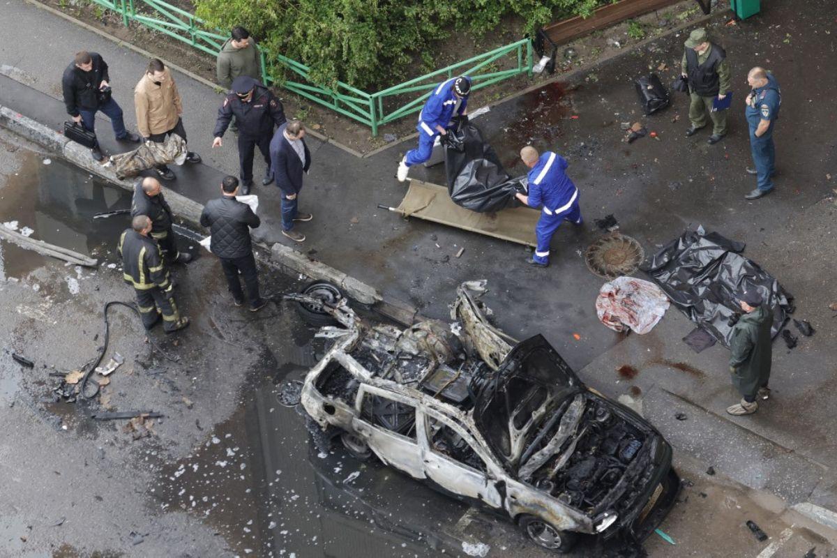 A Russian law enforcement officer stands next to the destroyed car. Photo: AFP