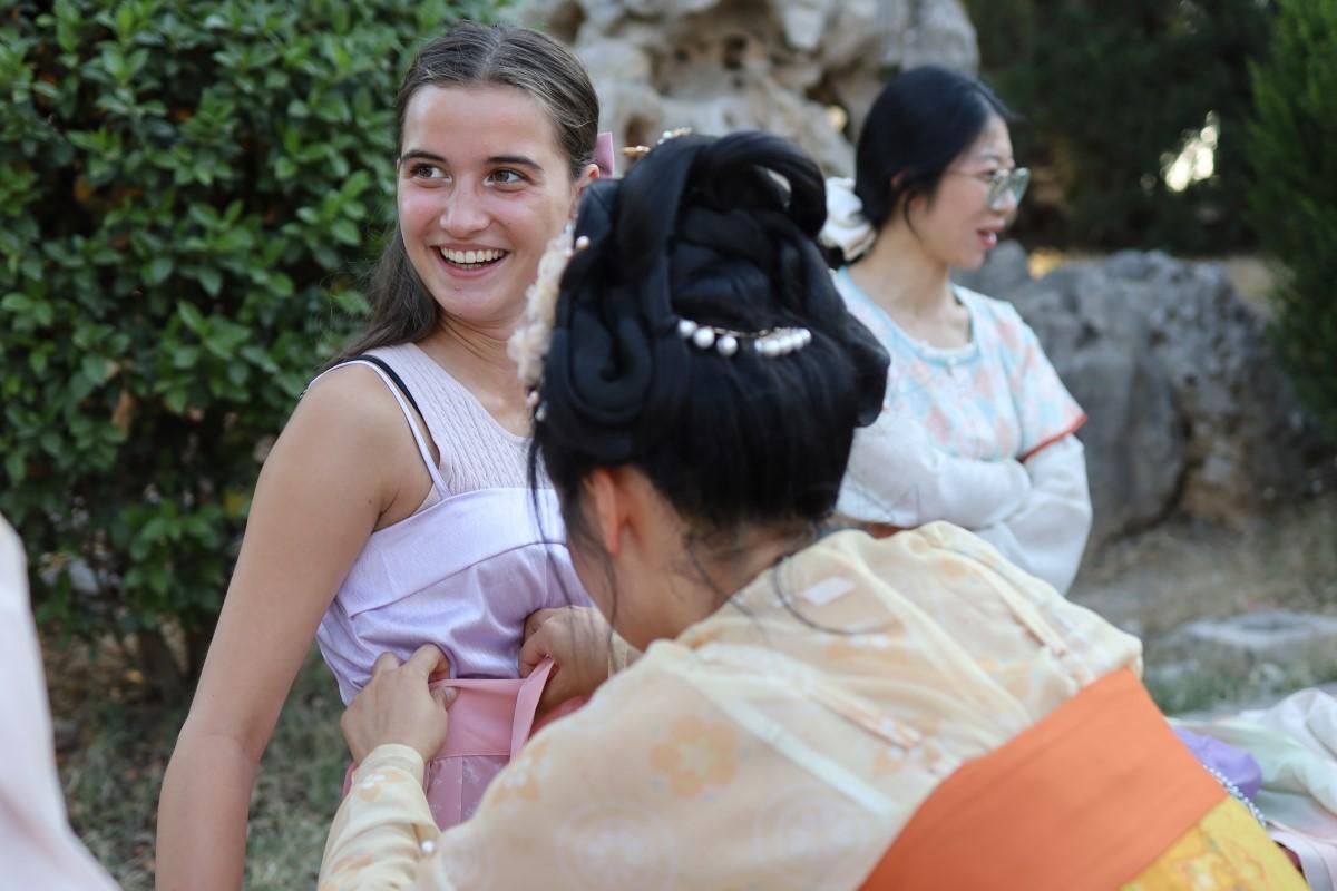 A girl trying on traditional Hanfu clothes.