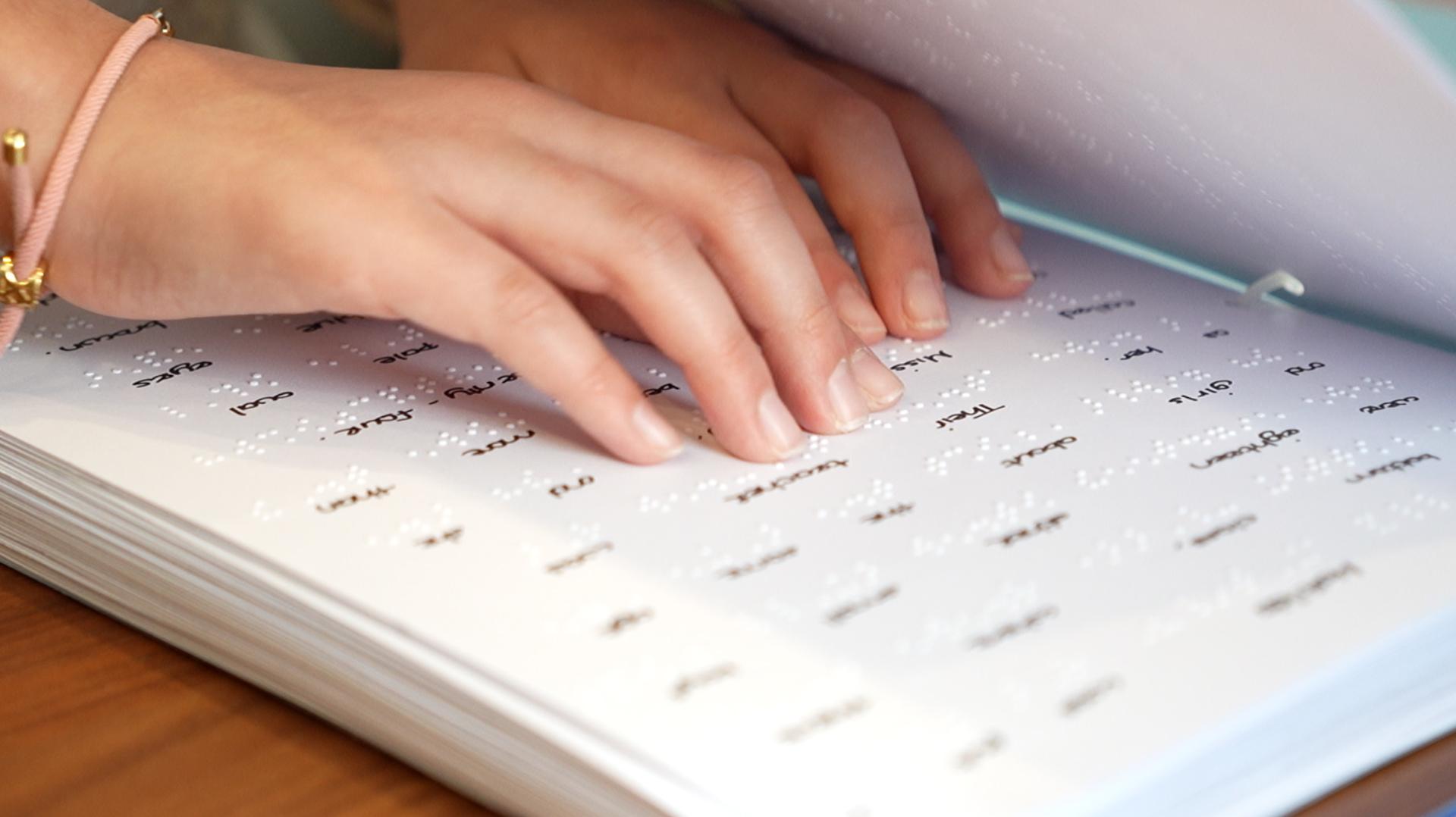 Melania reading using Braille.