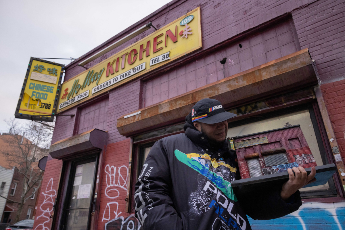 Cortes holds a miniature of Ho May Kitchen in Brooklyn.