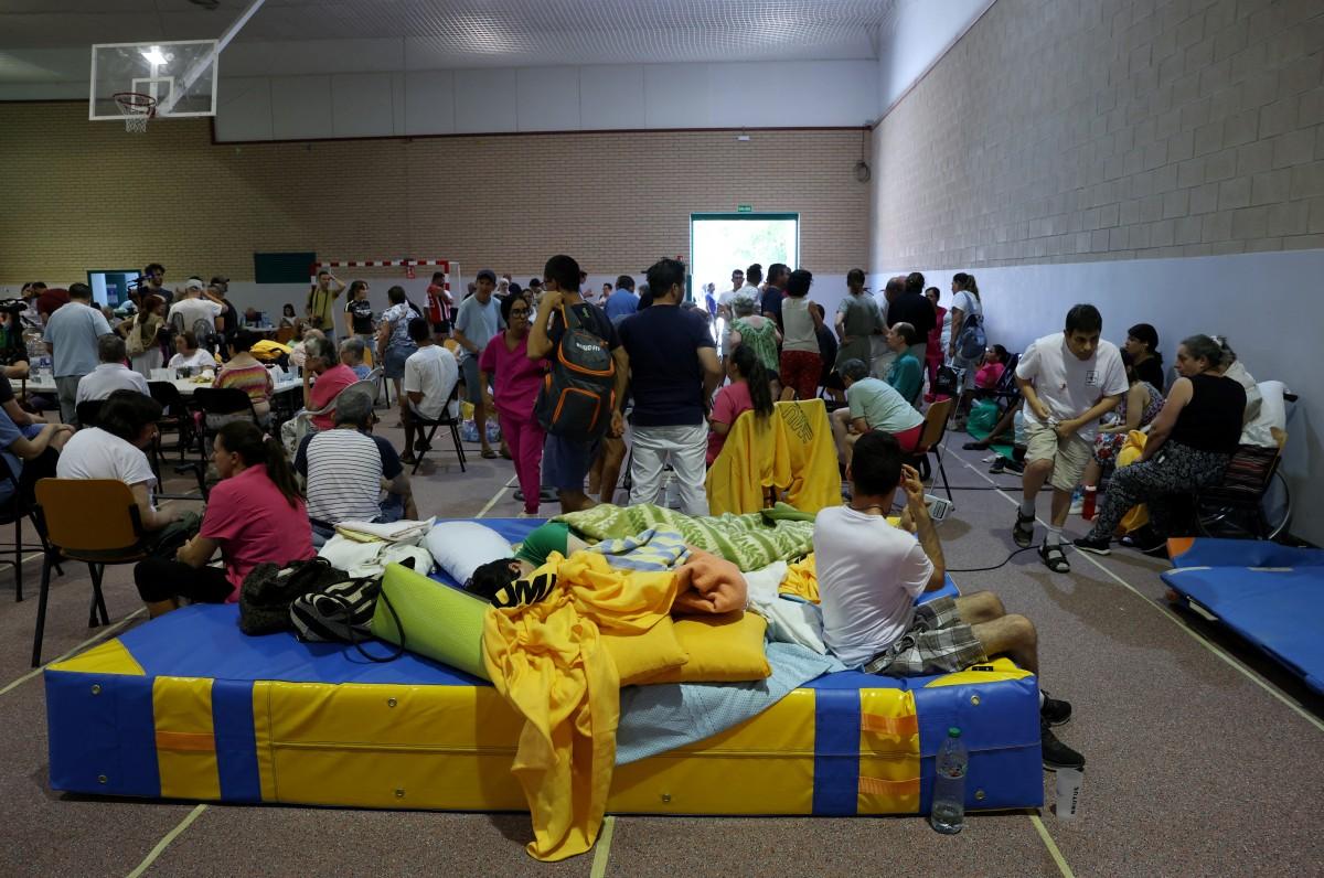 Residents evacuated from a wildfire near San Martin de Valdeiglesias take shelter in a sportshall in Villamanta. Photo: AFP