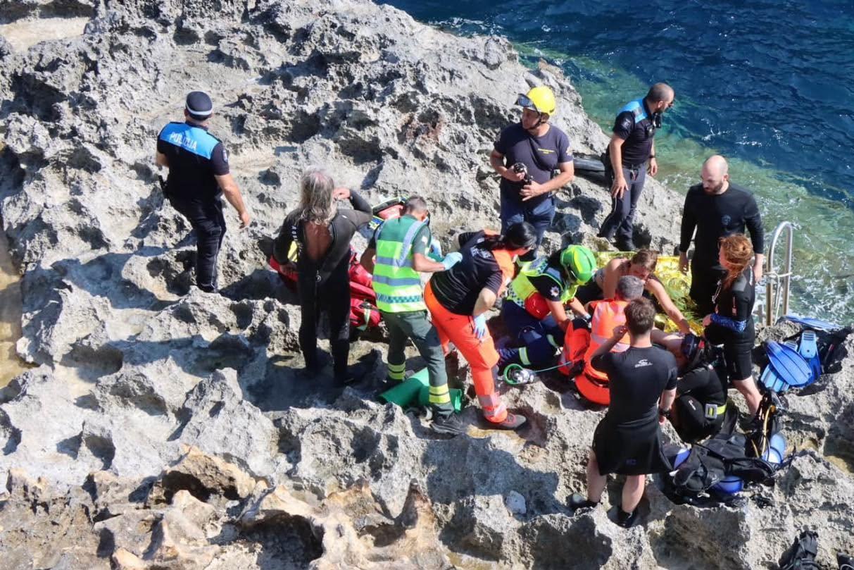 The diver is assisted after being brought to shore. CPD