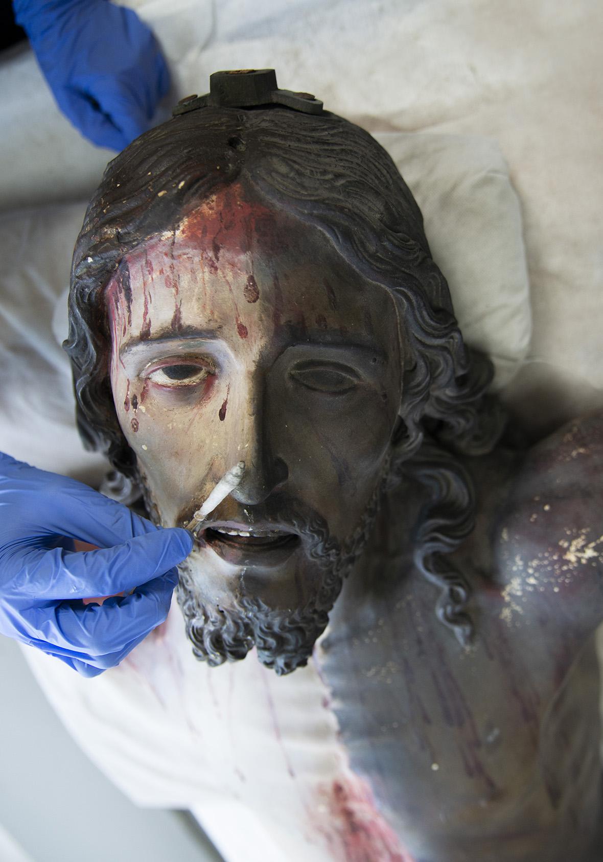 Detail of Christ&rsquo;s face, half cleaned, revealing the original polychromy.