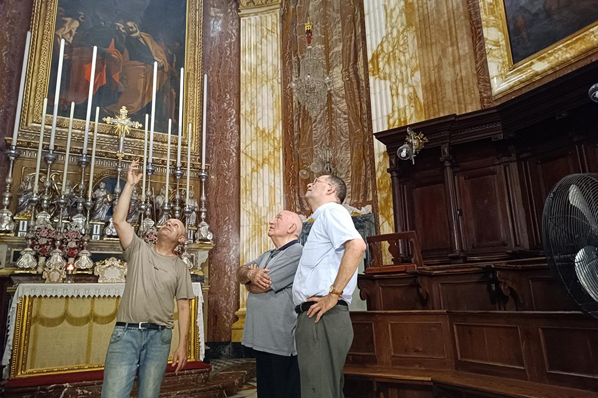 Mark Falzon (left) pointing out details of the restoration process of the painting to vice parish priest Can. Ruben Micallef (right) and parish collaborator and Comino chapel rector Mgr Joseph Attard.
