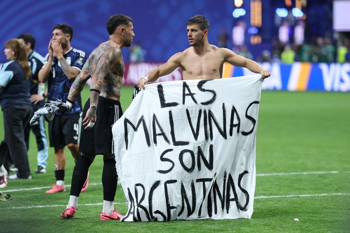 Argentina's defender #19 Nicolas Otamendi (L) and midfielder #11 Giovani Lo Celso show a banner that reads in Spanish, "The Malvinas (Falkland Islands) belong to Argentina," after winning the 2026 World Cup football tournament semi-final match. Photo: AFP