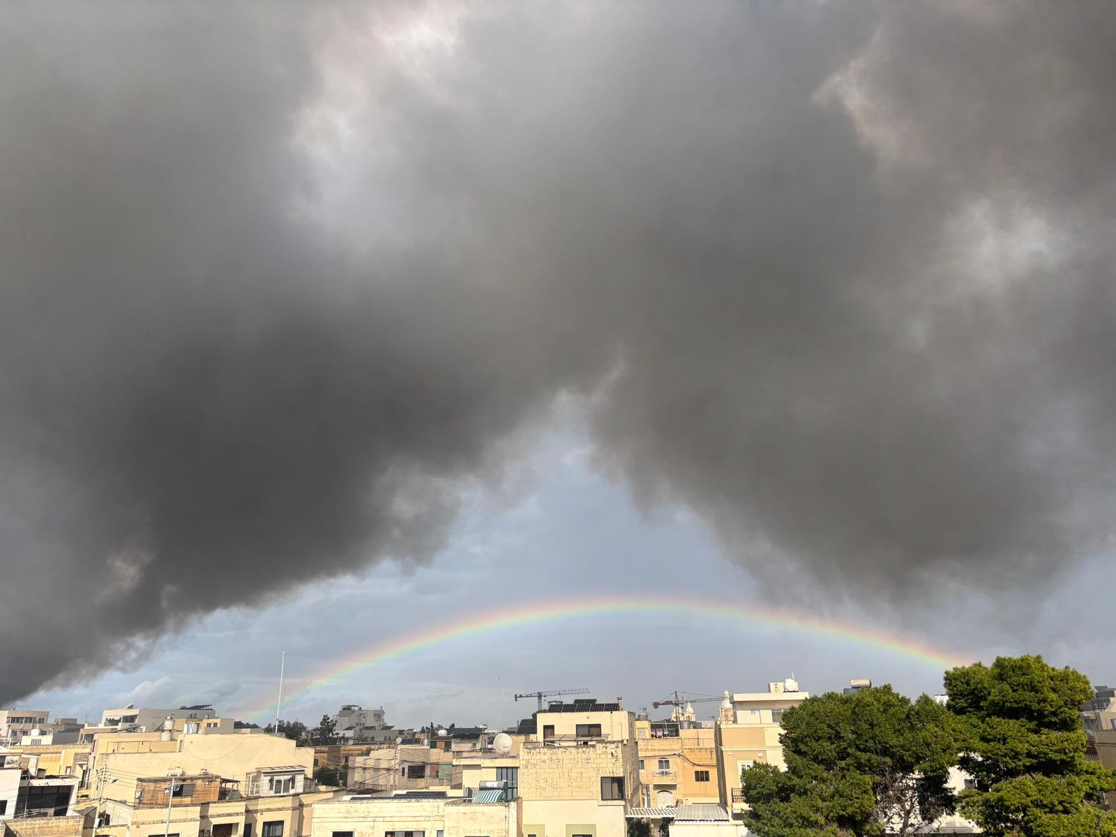 This image captured by reader Leonora Azzopardi shows a rainbow arching underneath the smoke.[/attach<em>]</em></p>