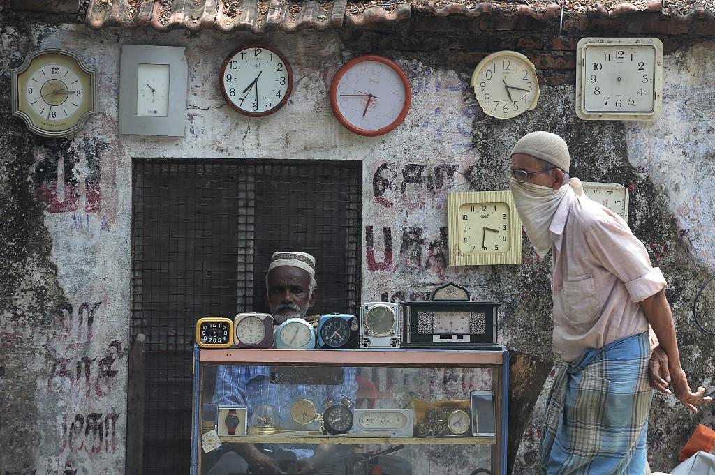 A watchmaker waits for customers in Chennai, India. Photo: AFP