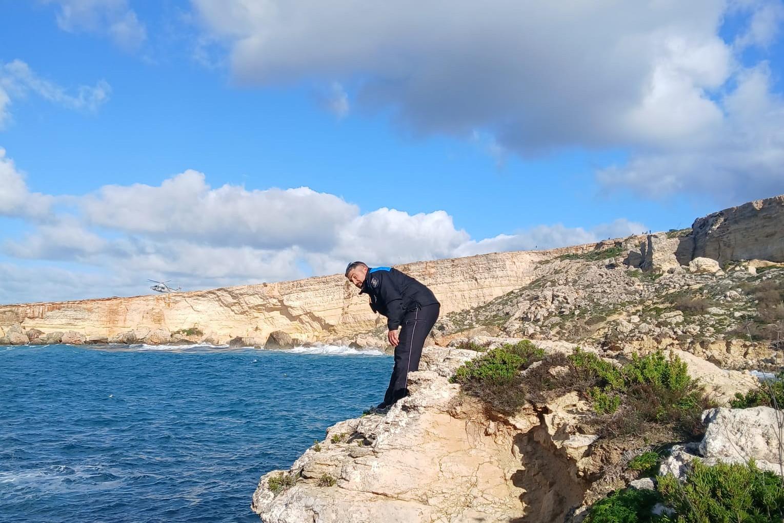 A policeman looking for the missing girl on the shoreline. Photo: Malta Police