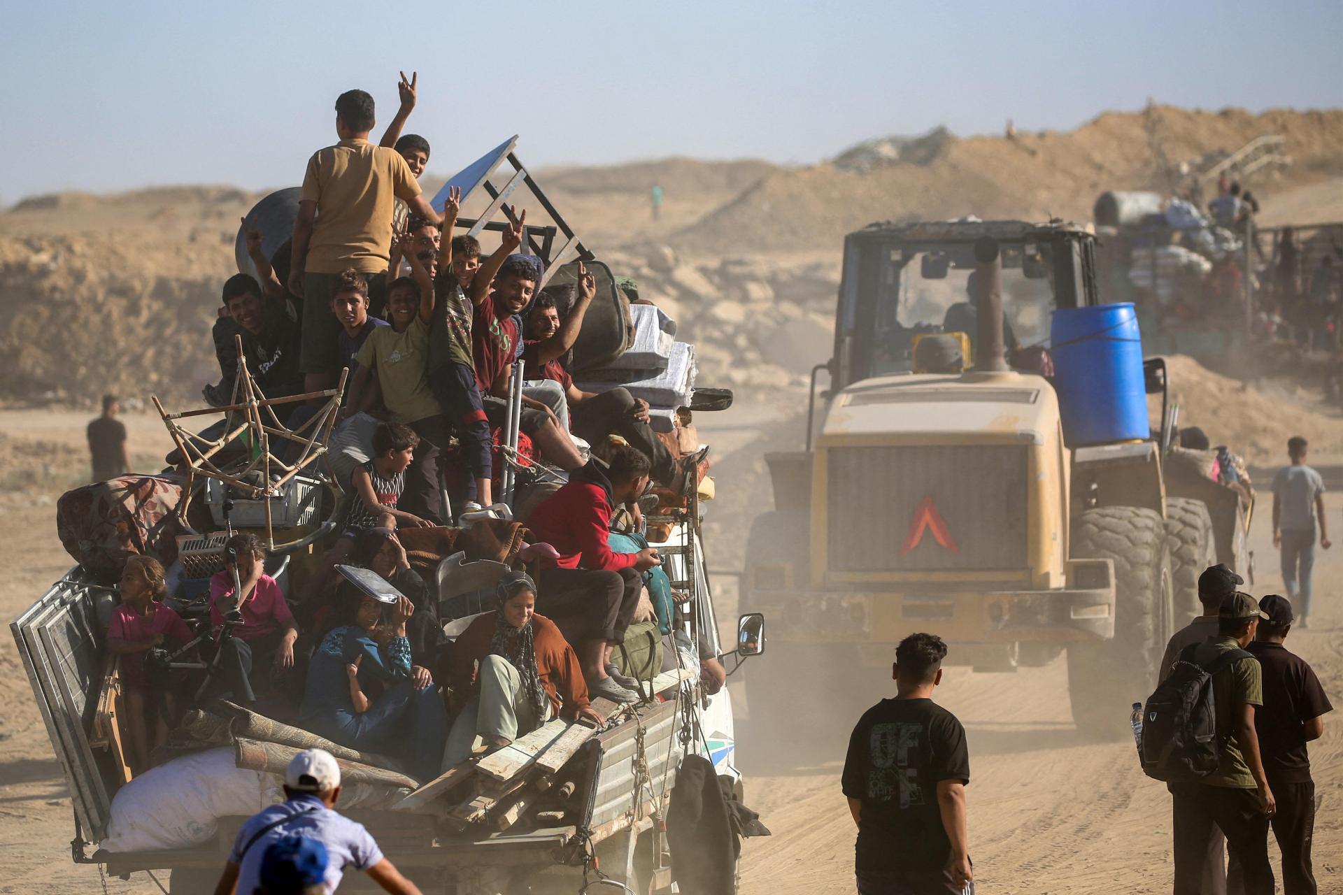 Palestinians flash the V for victory sign as they make their way to Gaza City through the so-called "Netzarim corridor" from Nuseirat in the central Gaza Strip. Photo: AFP