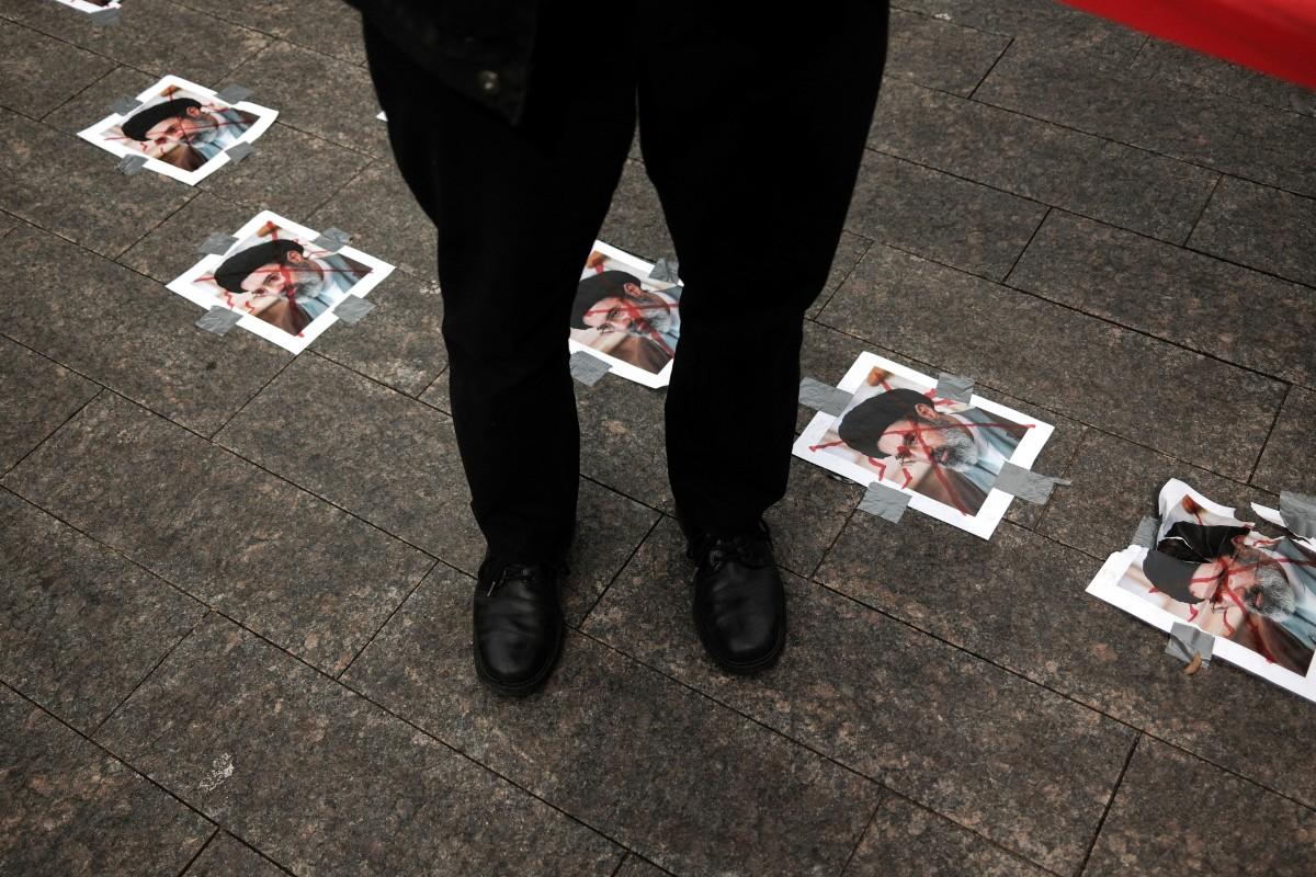 A person stands in front of crossed out portraits of new Iranian Supreme Leader Mojtaba Khamenei pasted on the ground as people gather to support regime change in Iran, in New York City this week. Photo: AFP