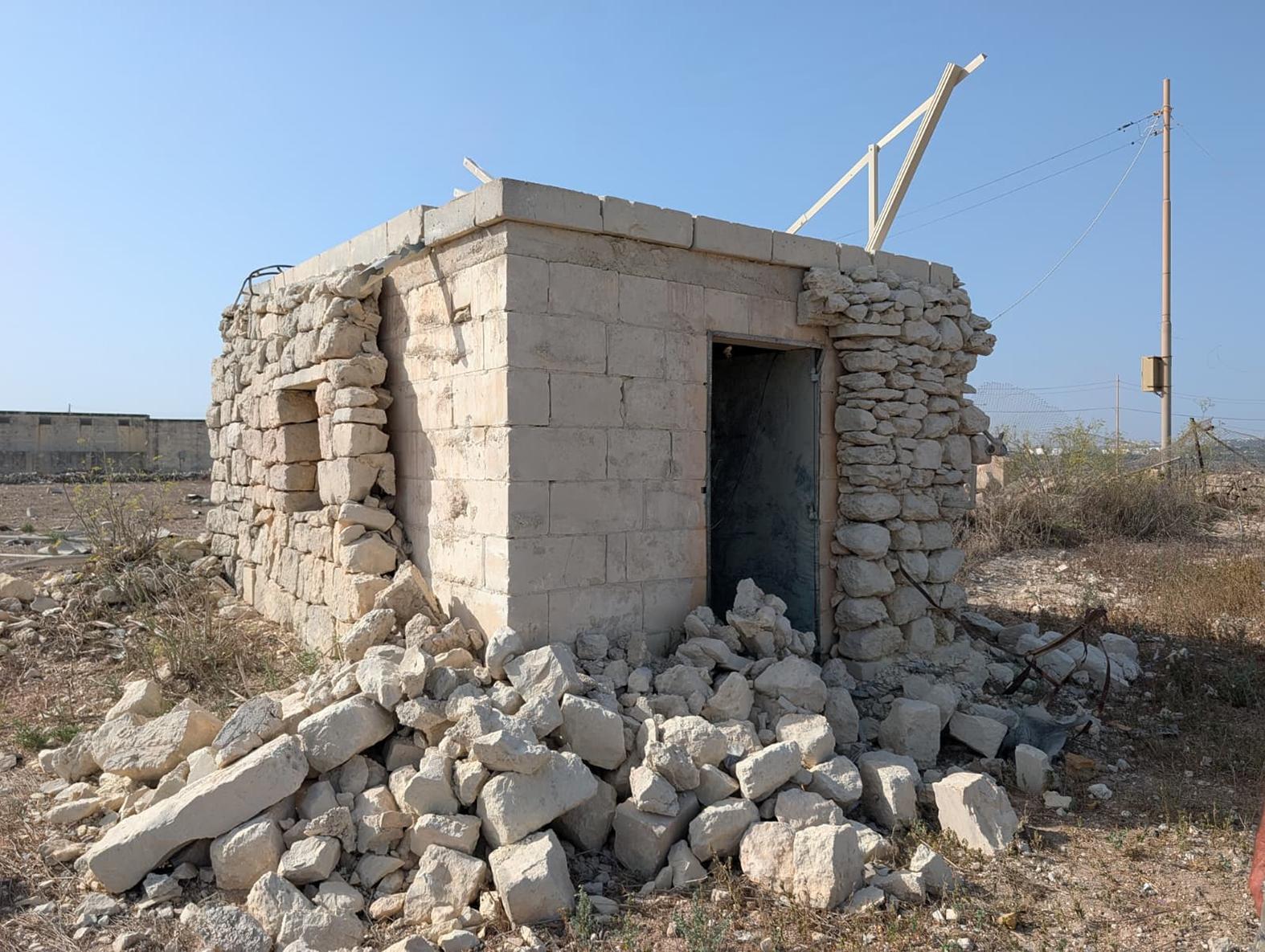 A room in the field with its rubble wall cladding partly destroyed.