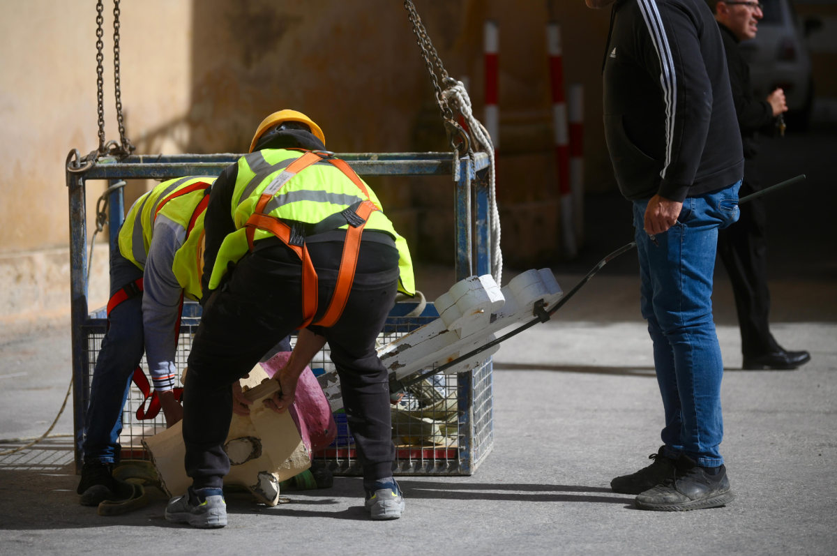Workers bring the cross safely to the ground. Photo: Jonathan Borg