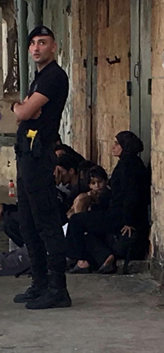 A police officer stands while boat passengers wait at Marsascala. Photo: Matthew Mirabelli