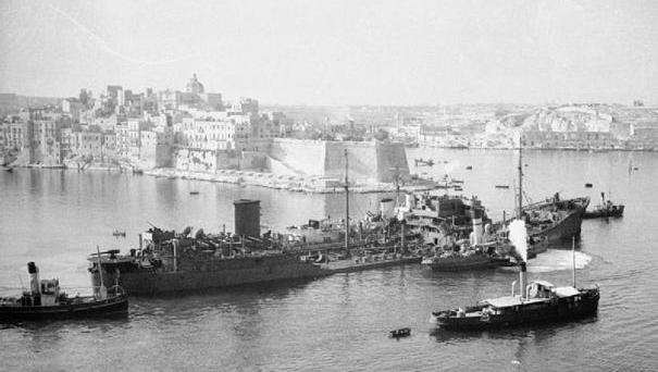 The tanker Ohio is ushered into Grand Harbour, kept afloat by destroyers on either side.