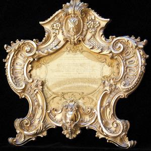 An ornate silver altar card, containing the texts of prayers, commonly known as Carta Gloria.
