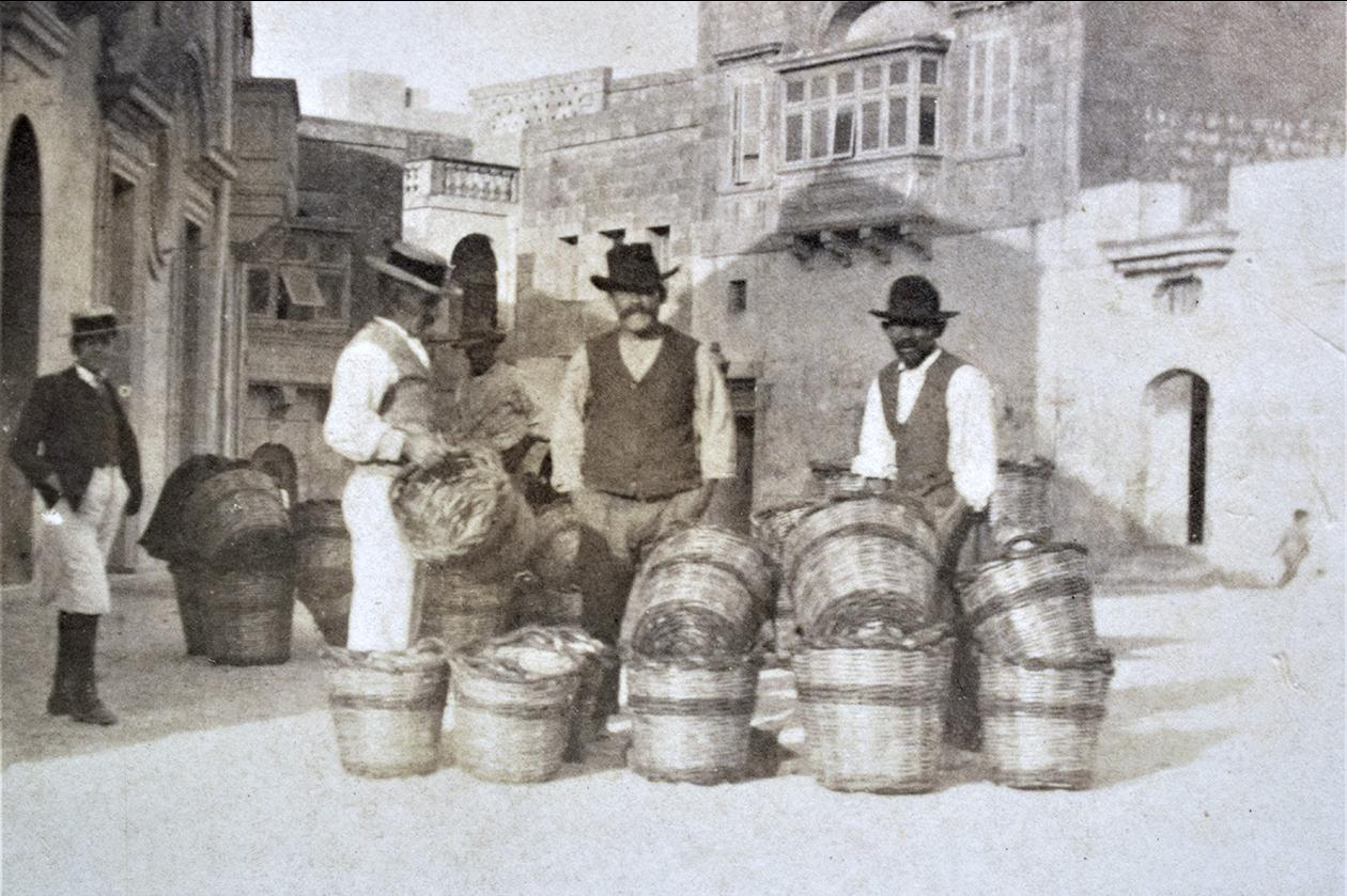A wicker basket weaver shown selling his wares in a 1910s postcard.