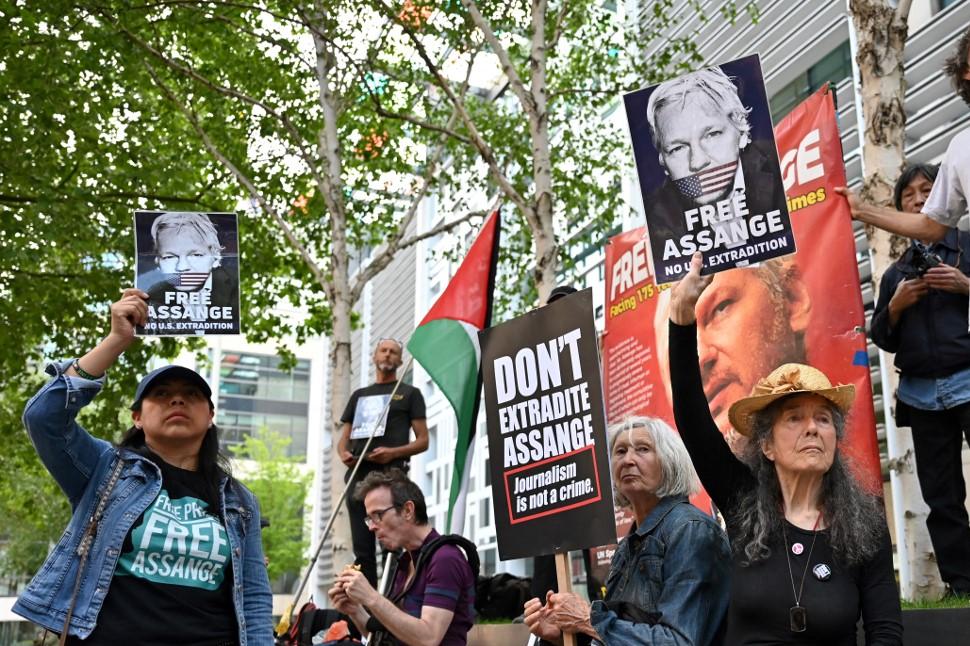 Demomstrators hold banners and placard as they gather in front of the Home Office building, in London, on May 17, 2022, during a demonstration to protest against the extradition of WikiLeaks founder Julian Assange. Photo: AFP