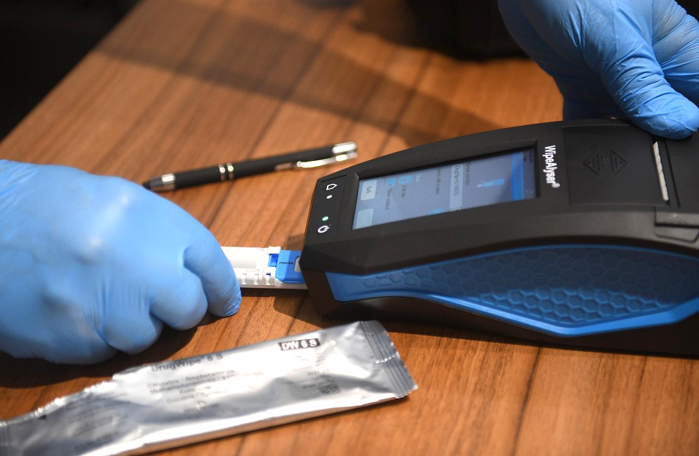 ue with a swab. Right: If there is a positive result, the next step is to take another sample to confirm the results, this time via a saliva swab that is tested in a lab. Photo: Matthew Mirabelli