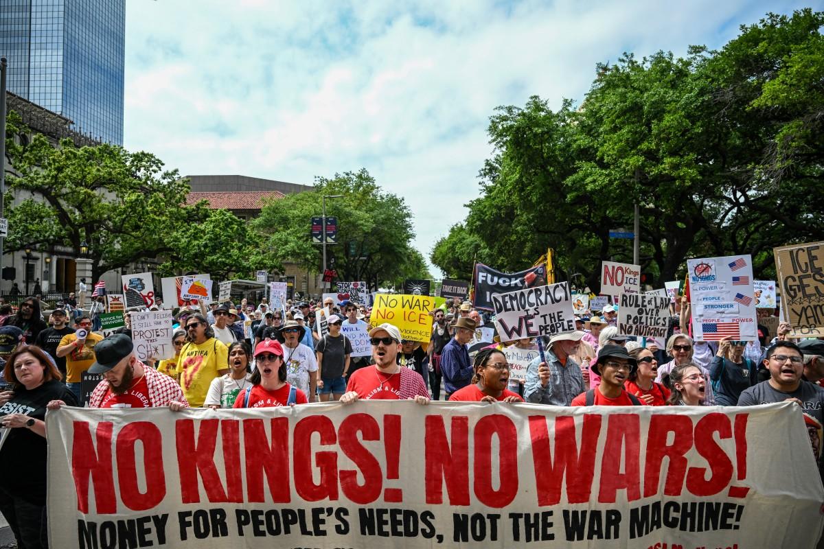 People holding signs march downtown in Houston. Photo: AFP