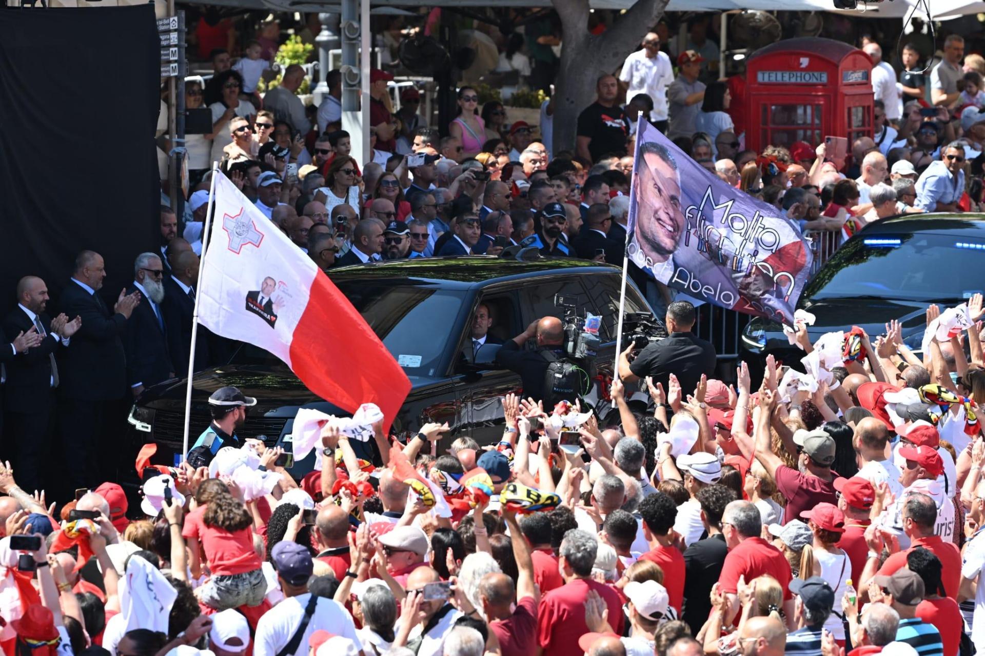 Crowds waving flags, one referencing the Labour party's historic fourth win. Photo: Matthew Mirabelli