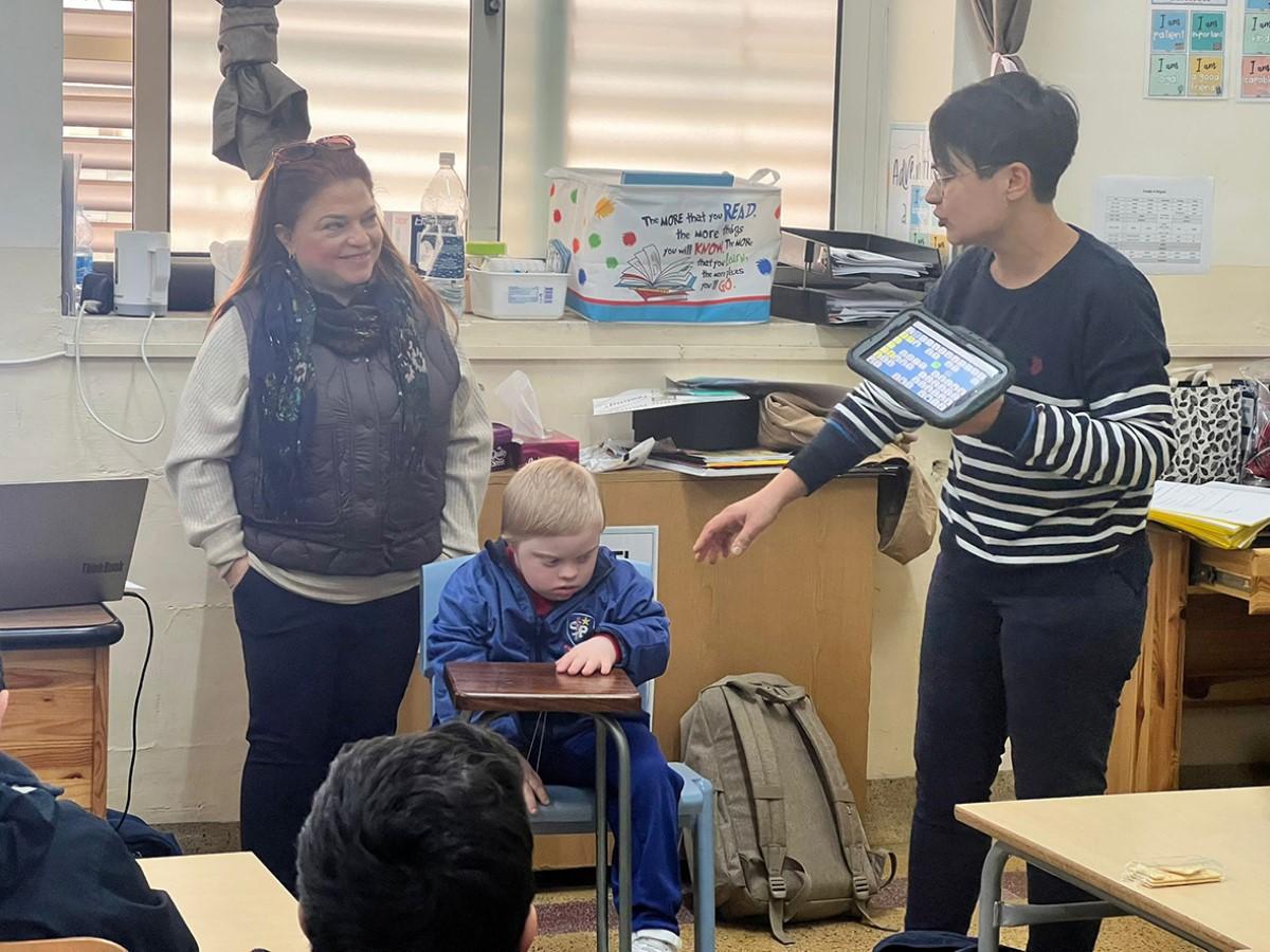 LSE Krystle Attard explaining how Grade 2 pupil Gabriel Papagiorcopulo, seen here with his mother, communicates using an AAC device.