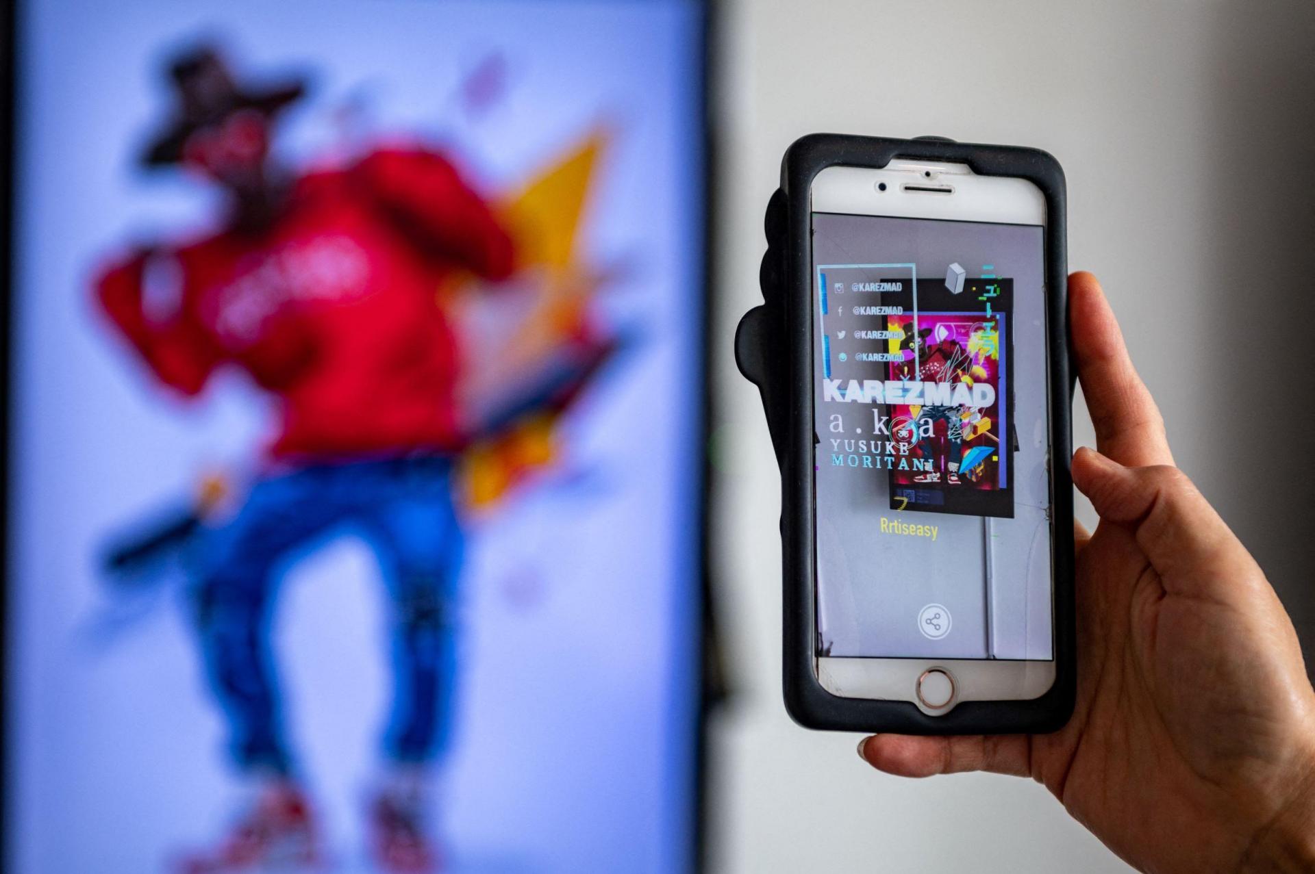 A visitor looking at artist Yasumasa Yonehara's &lsquo;Sup&rsquo; with a mobile phone app, during &lsquo;CrypTokyo&rsquo;.