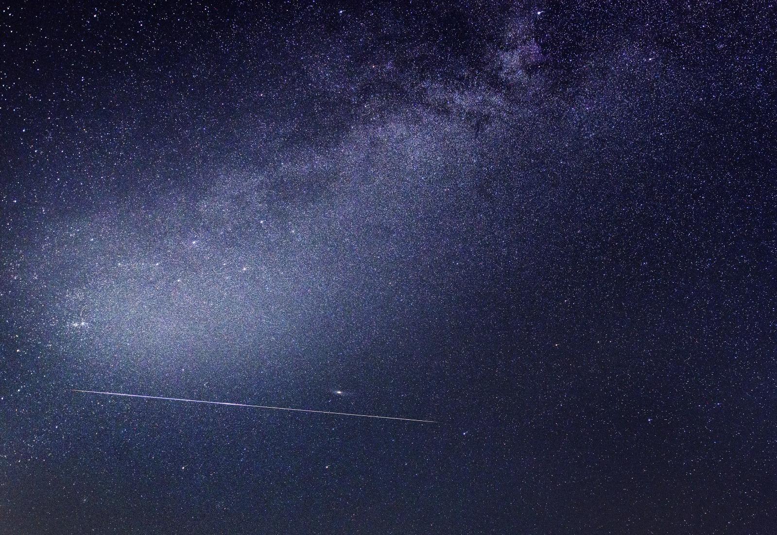 An image of a Perseid from August 2020. The small splotch of light above it is the Andromeda Galaxy. The fuzzy band of light stretching across the image is part of the Milky Way. Photo: Joseph Caruana